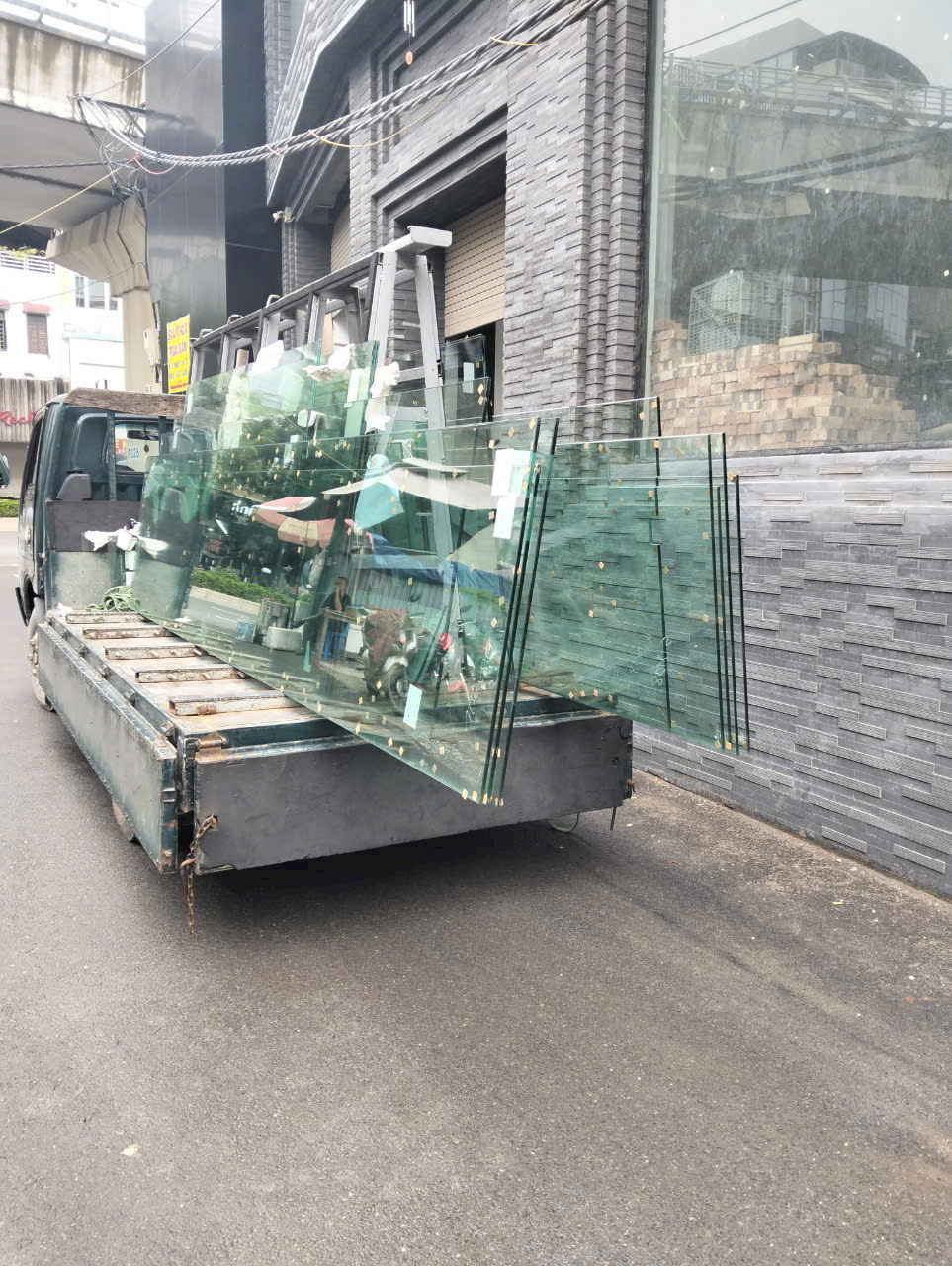 Các tấm kính cường lực lớn được xếp trên xe tải trước công trình xây dựng